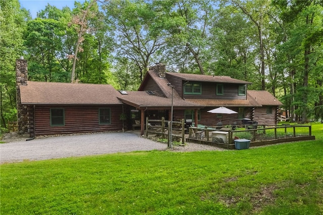 125 Timber Ridge Rd, Clinton Twp, PA 16056 - rear view of house with a chimney, log siding, a lawn, and gravel driveway