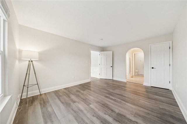 11 Sunset Ct, Cranberry Twp, PA 16066 - unfurnished bedroom with arched walkways, wood finished floors, and connected bathroom