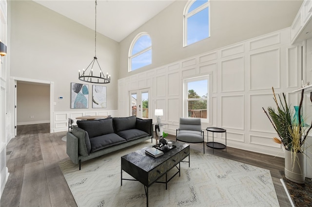 11 Sunset Ct, Cranberry Twp, PA 16066 - living area featuring a decorative wall, high vaulted ceiling, a chandelier, wood finished floors, and french doors