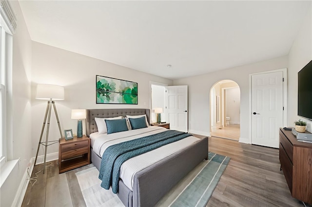 11 Sunset Ct, Cranberry Twp, PA 16066 - bedroom featuring arched walkways, wood finished floors, and ensuite bathroom