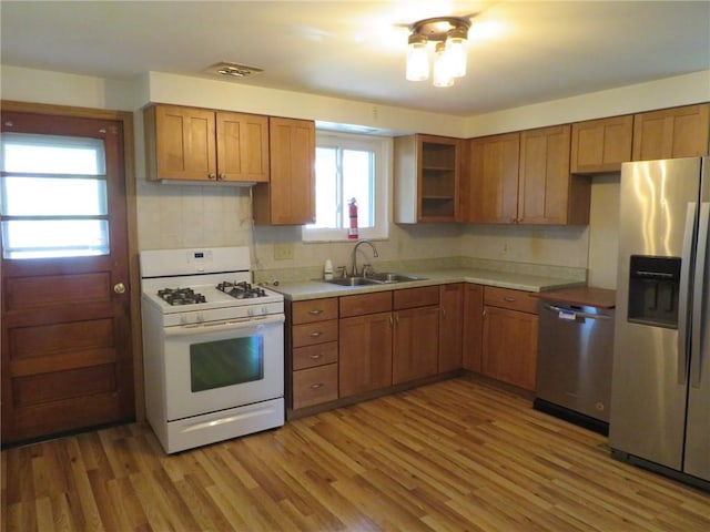 1332 Oakridge Rd, South Fayette, PA 15057 - kitchen with appliances with stainless steel finishes, brown cabinetry, light wood finished floors, and light countertops