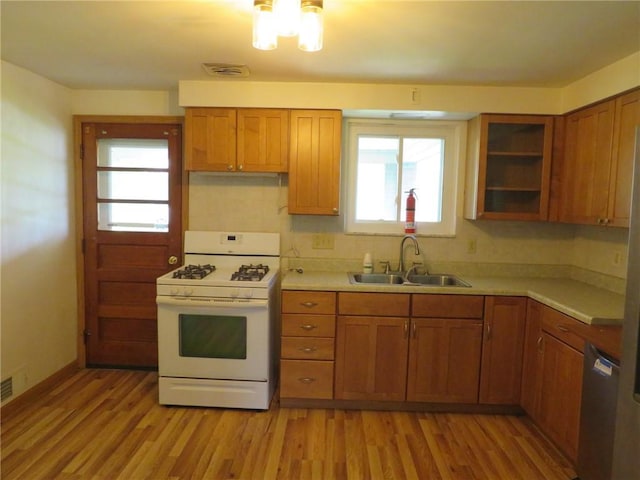 1332 Oakridge Rd, South Fayette, PA 15057 - kitchen featuring gas range gas stove, brown cabinetry, light countertops, and light wood-type flooring