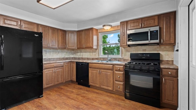 1127 State Route 885, Jefferson Hills, PA 15025 - kitchen featuring black appliances, light wood-style floors, brown cabinetry, and tasteful backsplash