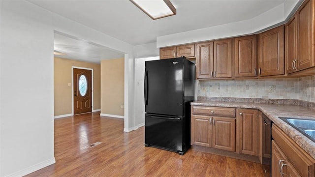1127 State Route 885, Jefferson Hills, PA 15025 - kitchen featuring freestanding refrigerator, backsplash, light wood-style floors, brown cabinetry, and dishwashing machine