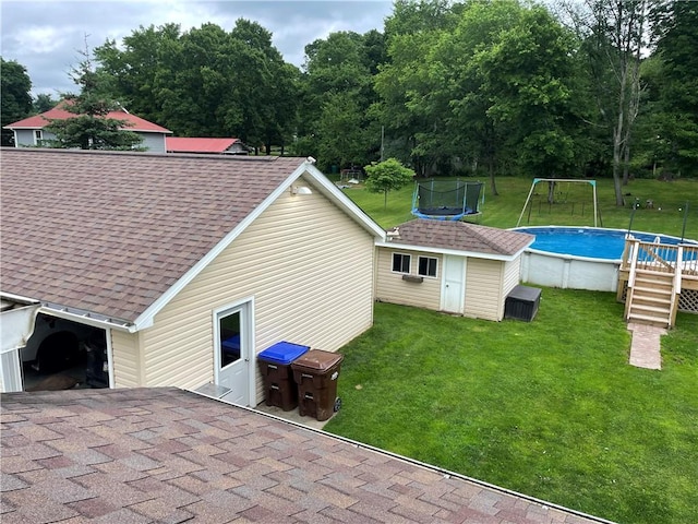 2568 Mercer St, Sandy Lake Boro, PA 16145 - rear view of property with a trampoline, roof with shingles, an outdoor pool, and a yard