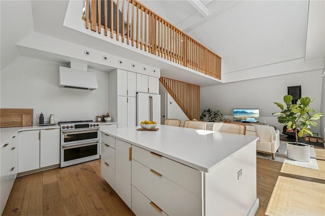 3019 Oak Ridge Ln, Saltlick Twp, PA 15622 - kitchen with high end appliances, ventilation hood, white cabinets, a kitchen island, and high vaulted ceiling
