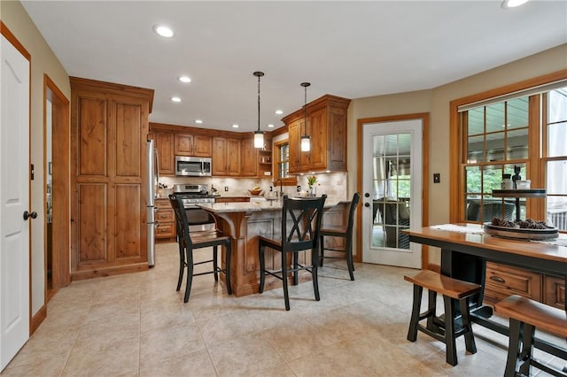 330 Warrick Dr, Seven Fields Boro, PA 16046 - kitchen featuring stainless steel appliances, brown cabinetry, recessed lighting, a peninsula, and tasteful backsplash