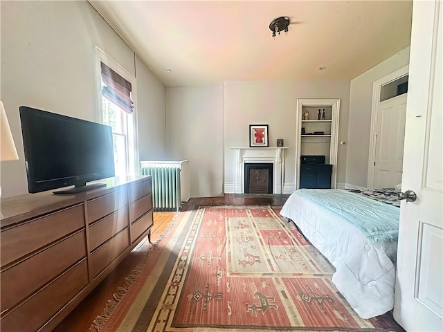 389 Rices Landing Rd, Luzerne Twp, PA 15433 - bedroom with radiator, a fireplace, and wood finished floors
