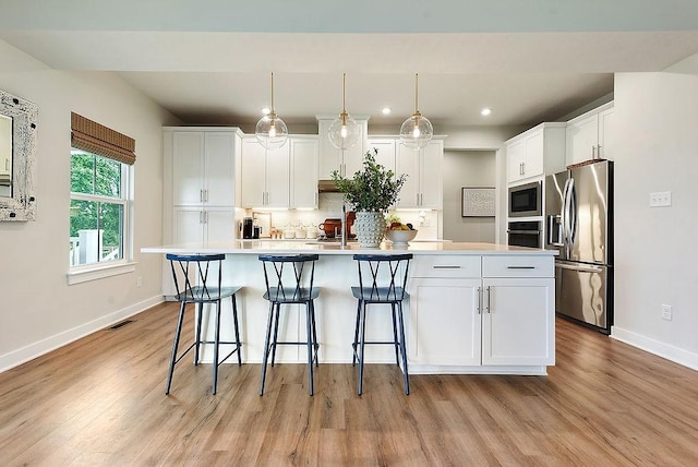 622 Burberry Blvd, Lehigh Twp, PA 16063 - kitchen with stainless steel appliances, light wood finished floors, an island with sink, white cabinetry, and tasteful backsplash