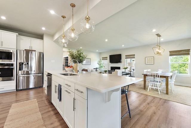 622 Burberry Blvd, Lehigh Twp, PA 16063 - kitchen featuring appliances with stainless steel finishes, light wood-style floors, white cabinetry, an island with sink, and light countertops