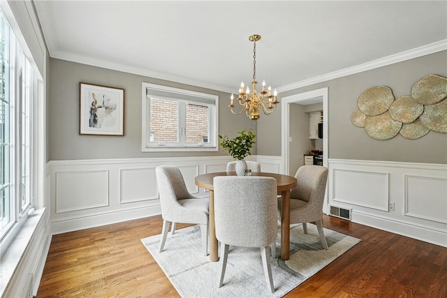 717 Kewanna Ave, Mt Lebanon, PA 15234 - dining space featuring a chandelier, crown molding, wood finished floors, wainscoting, and a decorative wall