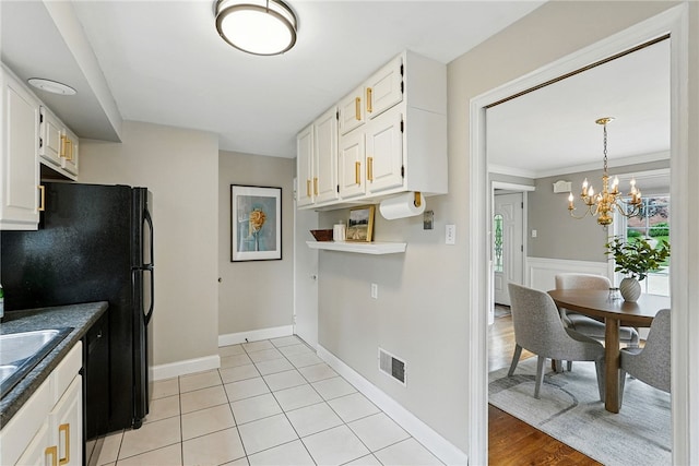 717 Kewanna Ave, Mt Lebanon, PA 15234 - kitchen with white cabinets, freestanding refrigerator, a chandelier, and dark countertops