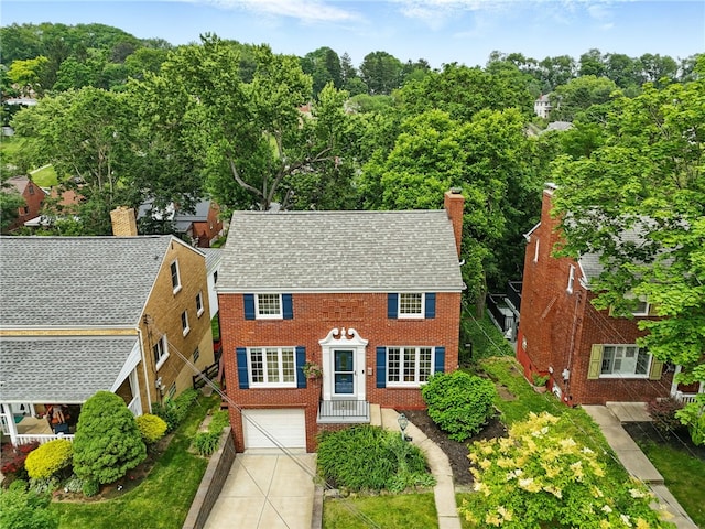 717 Kewanna Ave, Mt Lebanon, PA 15234 - colonial house featuring a garage, concrete driveway, brick siding, and a chimney