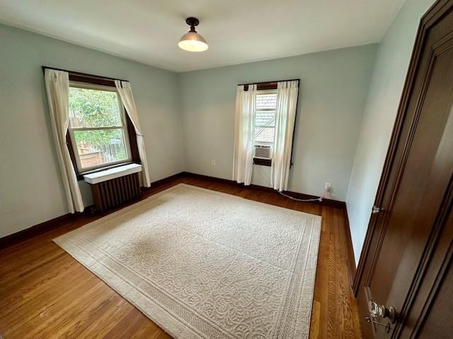 111 Race St, Regent Square, PA 15218 - empty room with radiator heating unit, healthy amount of natural light, and wood finished floors