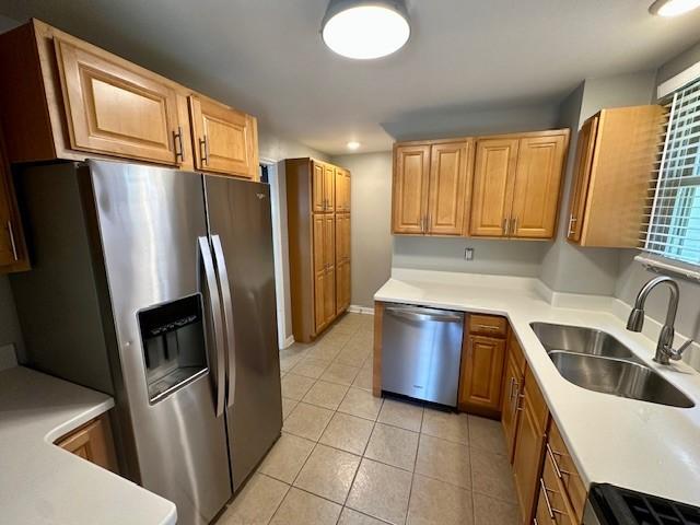 111 Race St, Regent Square, PA 15218 - kitchen with appliances with stainless steel finishes, light tile patterned flooring, light countertops, and brown cabinets