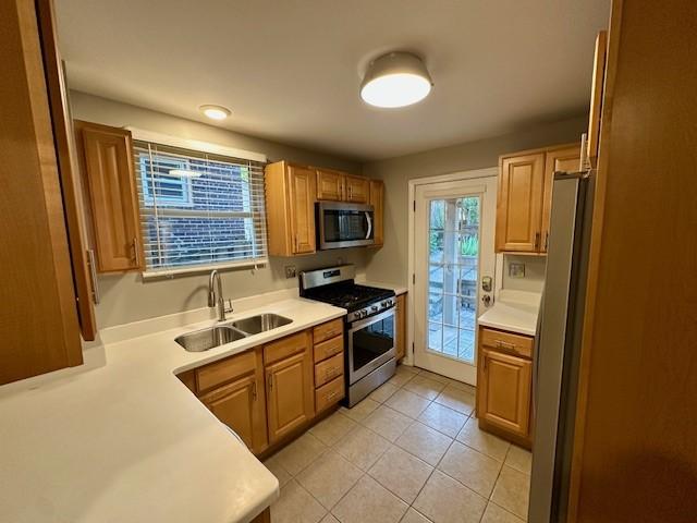 111 Race St, Edgewood, PA 15218 - kitchen with stainless steel appliances, light tile patterned flooring, and light countertops