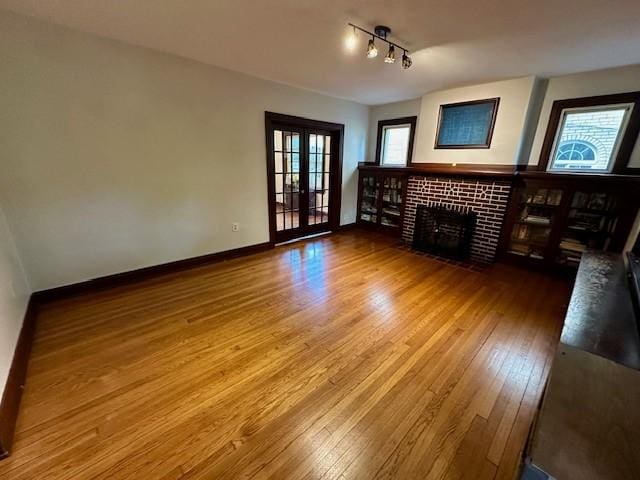 111 Race St, Edgewood, PA 15218 - unfurnished living room featuring wood-type flooring, a tile fireplace, and plenty of natural light