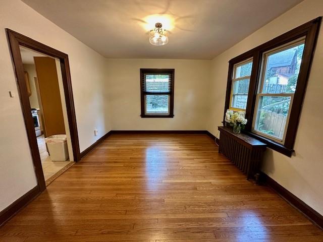 111 Race St, Edgewood, PA 15218 - spare room featuring wood finished floors, plenty of natural light, and radiator heating unit