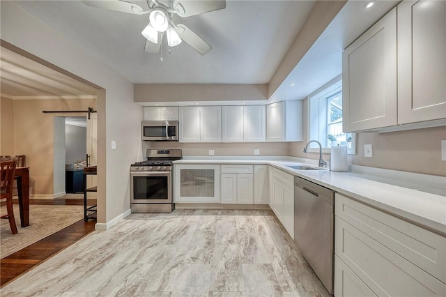 725 Dunster St, Brookline, PA 15226 - kitchen featuring stainless steel appliances, light countertops, white cabinetry, a ceiling fan, and a barn door