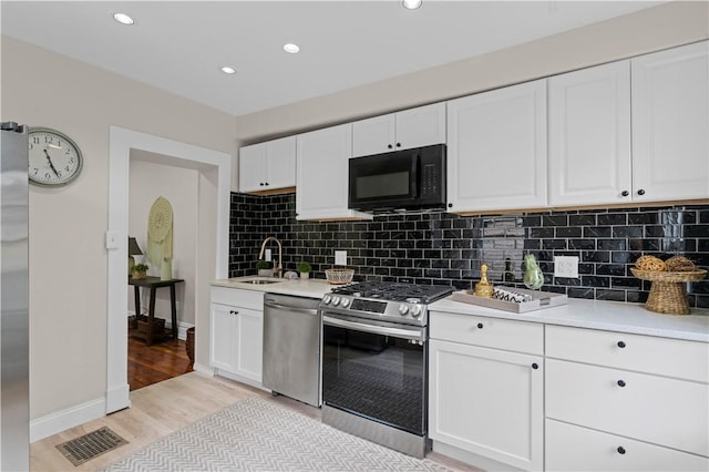 927 Greenfield Ave, Greenfield, PA 15217 - kitchen featuring appliances with stainless steel finishes, light wood-style flooring, light countertops, backsplash, and recessed lighting