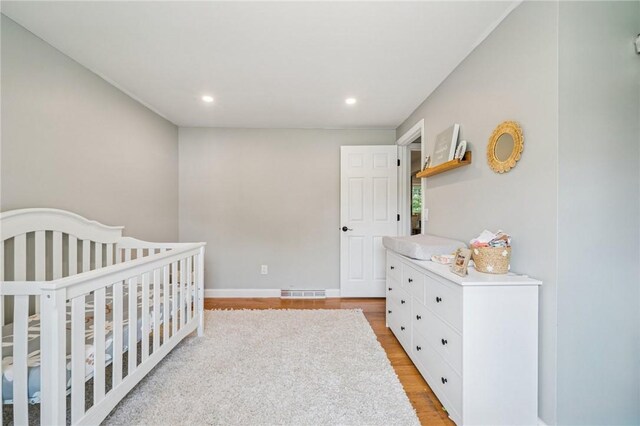 425 Sandy Dr, Shaler, PA 15116 - bedroom featuring light wood-style floors, recessed lighting, and a nursery area