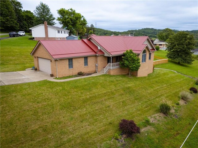 246 Johnston Rd, Bentleyville, PA 15314 - view of front facade featuring a metal roof, concrete driveway, brick siding, a front lawn, and covered porch