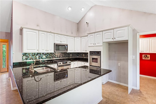 246 Johnston Rd, Bentleyville, PA 15314 - kitchen with stainless steel appliances, a peninsula, dark stone counters, white cabinetry, and backsplash