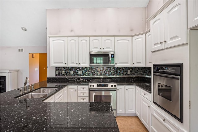 246 Johnston Rd, Bentleyville, PA 15314 - kitchen with appliances with stainless steel finishes, white cabinets, decorative backsplash, dark stone countertops, and a peninsula