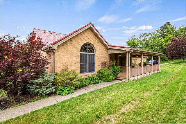 246 Johnston Rd, Bentleyville, PA 15314 - view of property exterior featuring a lawn, brick siding, a ceiling fan, and a porch