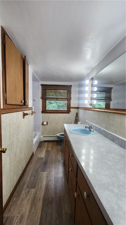 1008 Wallace St, Vandergrift Wml, PA 15690 - full bathroom featuring vanity, wood finished floors, baseboard heating, and bathing tub / shower combination