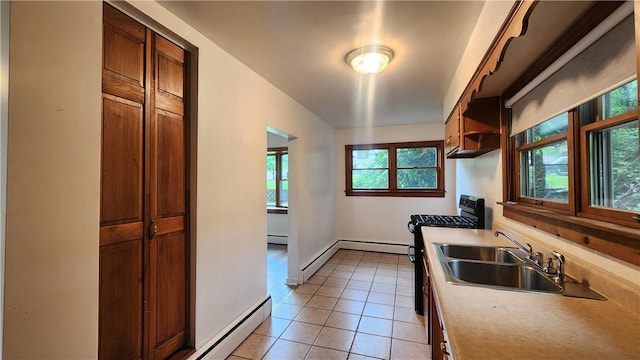 1008 Wallace St, Vandergrift Wml, PA 15690 - kitchen featuring gas range, light tile patterned flooring, brown cabinetry, light countertops, and a baseboard heating unit
