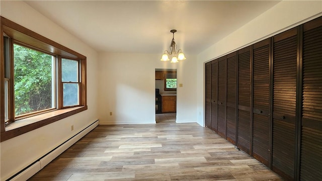 1008 Wallace St, Vandergrift Wml, PA 15690 - unfurnished dining area with baseboard heating, a chandelier, and light wood-type flooring