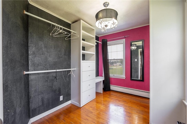 4177 Main St, Cook Twp, PA 15687 - walk in closet featuring baseboard heating, wood-type flooring, and a chandelier