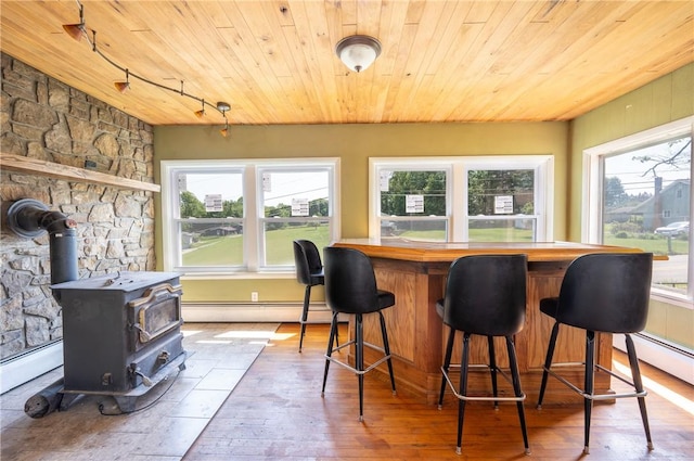 4177 Main St, Cook Twp, PA 15687 - dining space featuring wooden ceiling, a baseboard heating unit, a wood stove, hardwood / wood-style flooring, and a bar