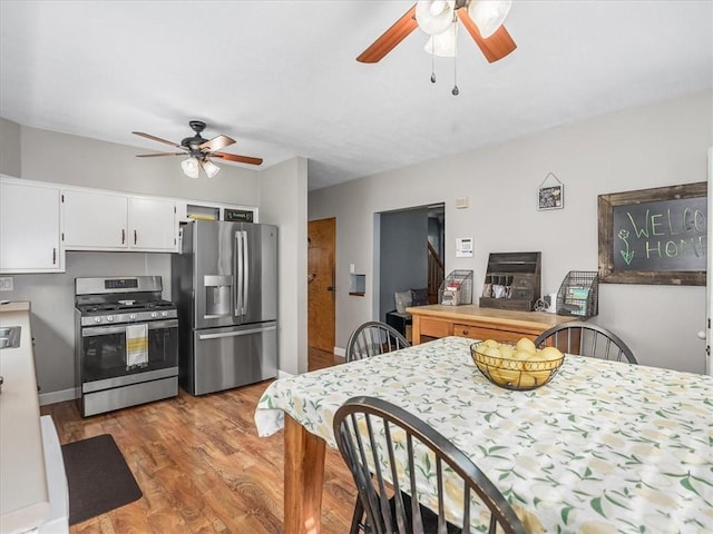 1713 Buchanan Ext, Aliquippa, PA 15001 - kitchen with appliances with stainless steel finishes, a ceiling fan, light wood-style floors, and white cabinetry