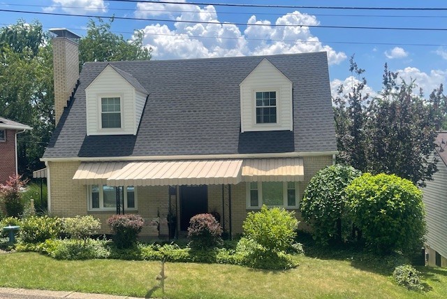 1713 Buchanan Ext, Aliquippa, PA 15001 - cape cod-style house featuring brick siding, a front lawn, and a chimney