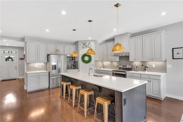 205 Regency Dr, North Strabane, PA 15330 - kitchen with stainless steel appliances, decorative backsplash, dark wood-style flooring, a kitchen breakfast bar, and recessed lighting