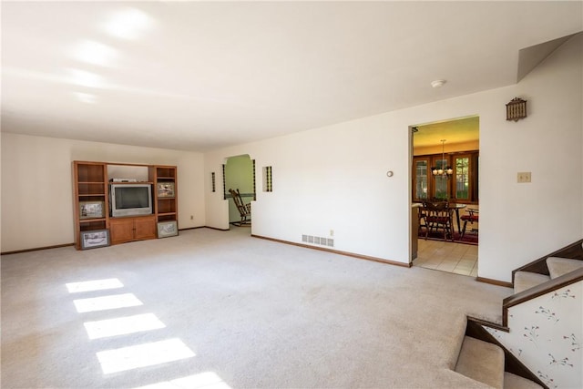 756 Arona Rd, Hempfield Twp Wml, PA 15672 - unfurnished living room with a chandelier, light carpet, and stairway