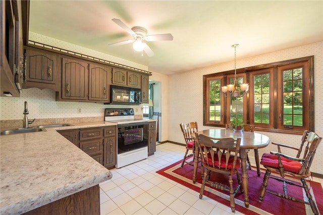 756 Arona Rd, Hempfield Twp Wml, PA 15672 - kitchen with range with electric stovetop, black microwave, wallpapered walls, light countertops, and a chandelier