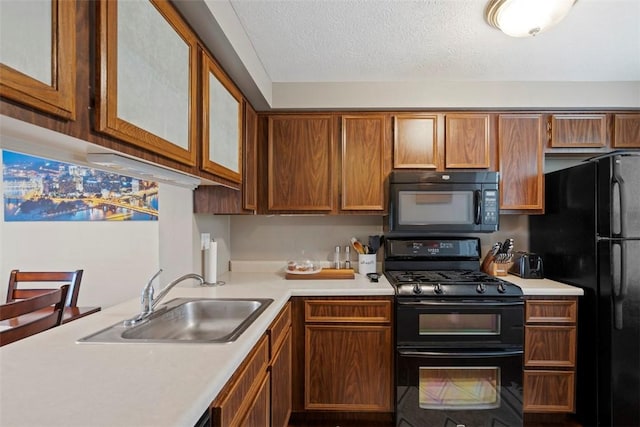 410 Redrome Cir E, South Fayette, PA 15017 - kitchen featuring black appliances, light countertops, brown cabinetry, glass insert cabinets, and a textured ceiling