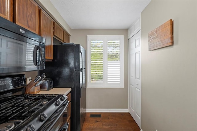 410 Redrome Cir E, South Fayette, PA 15017 - kitchen with gas range oven, black microwave, dark wood-style floors, and brown cabinetry