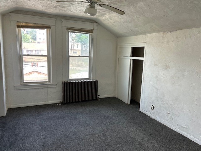 2618 Salisbury St, South Side, PA 15210 - unfurnished bedroom with radiator, lofted ceiling, dark colored carpet, multiple windows, and ceiling fan