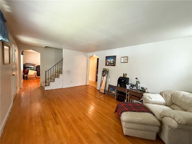 1320 Main St, Bridgeville, PA 15017 - living area featuring arched walkways, light wood-type flooring, and stairway