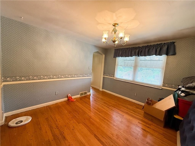 1320 Main St, Bridgeville, PA 15017 - dining space with wood finished floors, wallpapered walls, a chandelier, and arched walkways