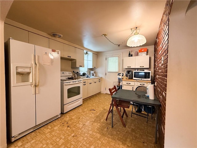 1320 Main St, Bridgeville, PA 15017 - kitchen with white appliances, light flooring, brick wall, white cabinetry, and light countertops