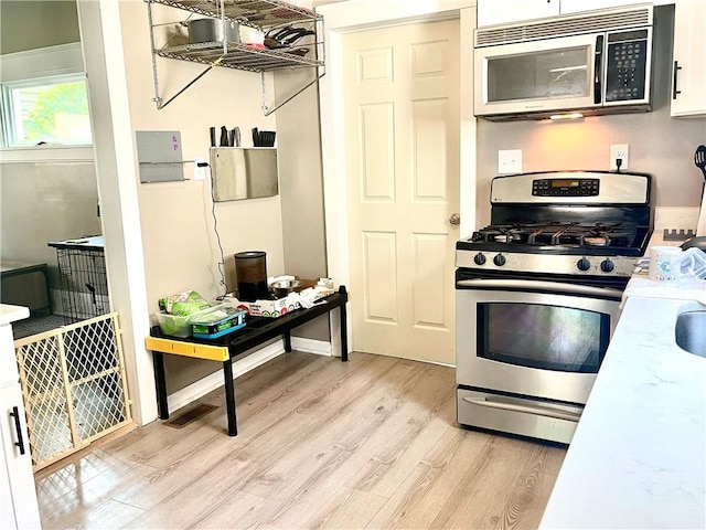 424 Hess Ave, Erie City, PA 16507 - kitchen with appliances with stainless steel finishes, light wood-type flooring, light countertops, and white cabinets