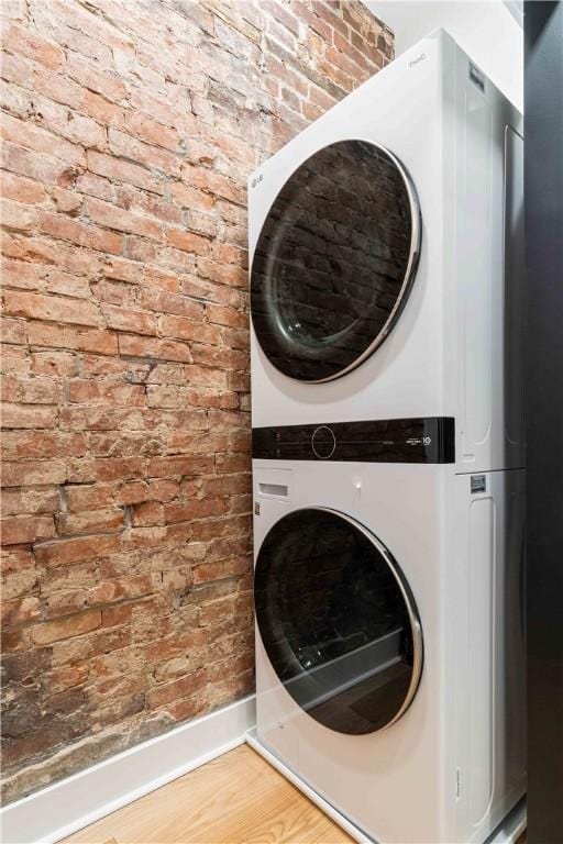 161 Morewood, Oakland, PA 15213 - laundry room with estacked washer and dryer, brick wall, and wood finished floors