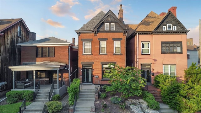 625 S Aiken Ave, Shadyside, PA 15232 - view of front facade with brick siding, a chimney, covered porch, and stairway