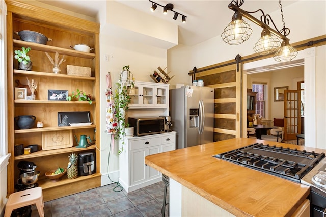 625 S Aiken Ave, Shadyside, PA 15232 - kitchen with stainless steel appliances, a barn door, dark tile patterned flooring, white cabinets, and glass insert cabinets
