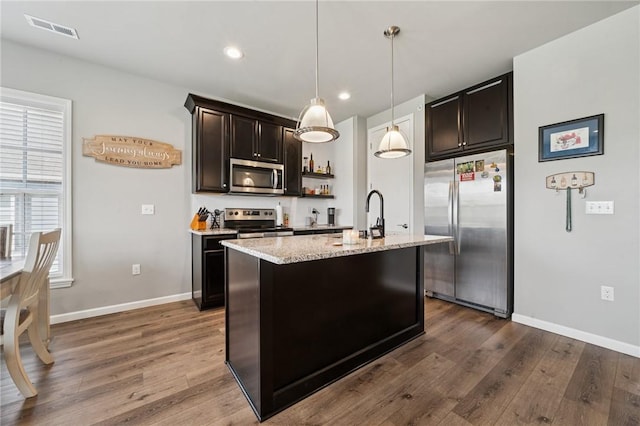 1431 Hastings Cres, South Fayette, PA 15017 - kitchen with stainless steel appliances, dark wood-style floors, light stone countertops, pendant lighting, and a center island with sink